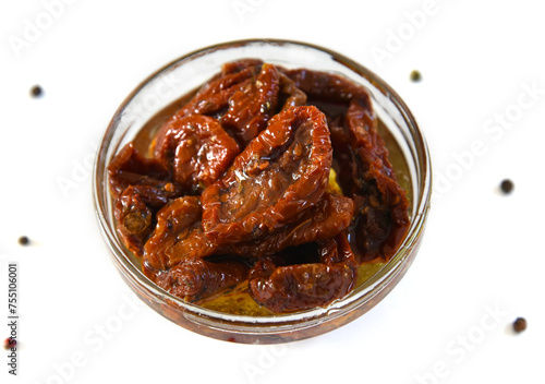 Plate with dried tomatoes in oil isolated on white background with pepper, top view. Healthy food. Great snack.