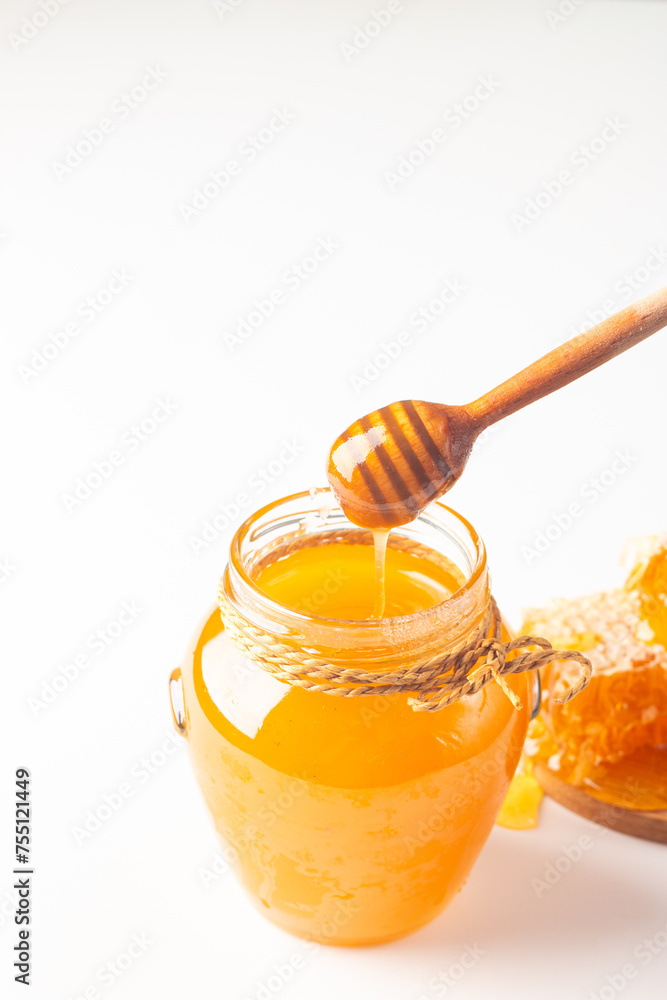 Honey dripping from a wooden honey dipper on white background. Healthy organic food concept. Honey dripping from a wooden honey dipper on white background. Healthy organic food concept.