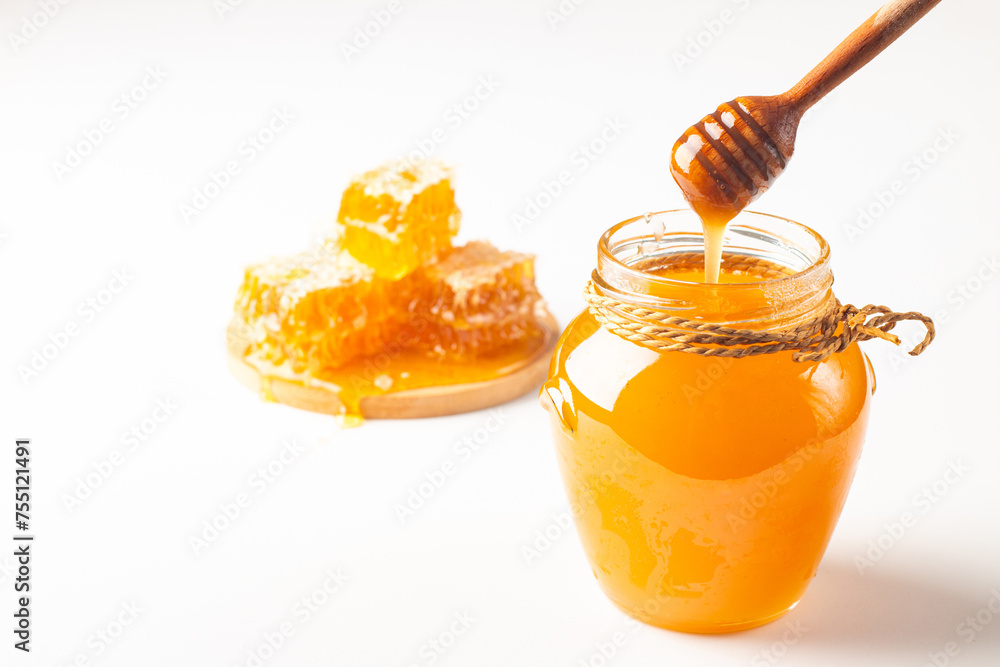 Honey dripping from a wooden honey dipper on white background. Healthy organic food concept. Honey dripping from a wooden honey dipper on white background. Healthy organic food concept.