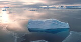 Blue glacier reflected in frozen ice ocean surface. Antarctica sunset landscape panorama. Huge ice iceberg at polar nature environment. Travel, explore icy wonders. Aerial drone flight