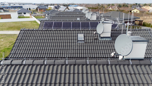Panele słoneczne na dachu budynku jednorodzinnego, ekologia, dachy kilku budynków.