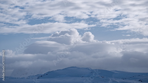 White clouds over mountain range aerial. Antarctica desert landscape of polar natural beauty. Epic nature scenery of arctic winter at cloudy day. Environment preserve scene of global warming