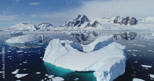 Close up polar seascape with iceberg at ocean bay aerial. Snow covered mountain at coast. Arctic melting fiord of ice. Global warming environment preservation. Cinematic climate change at Antarctica photo