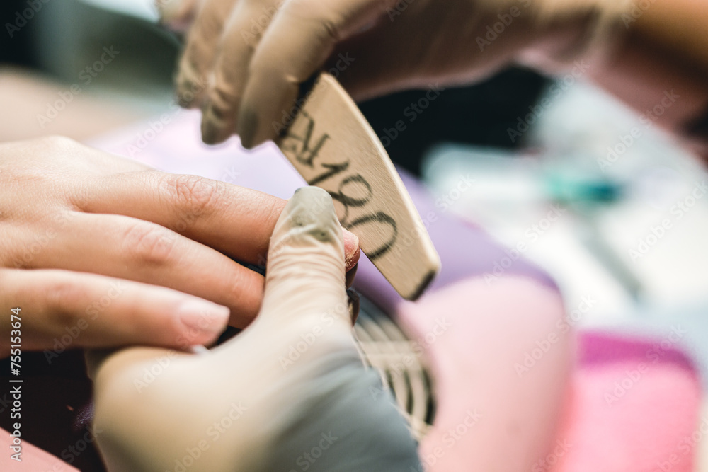 Fototapeta premium A beautician doing a manicure on a woman in her nail salon