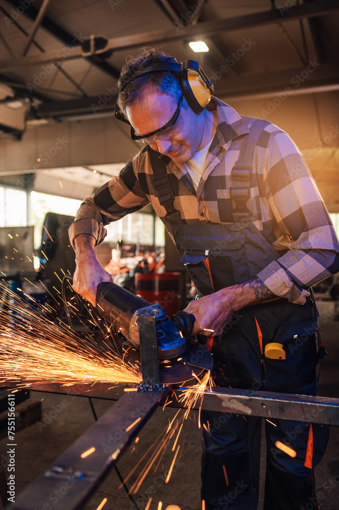 Caucasian man working hard with his grinder while spark flying around. Caucasian man working hard with his grinder while spark flying around.