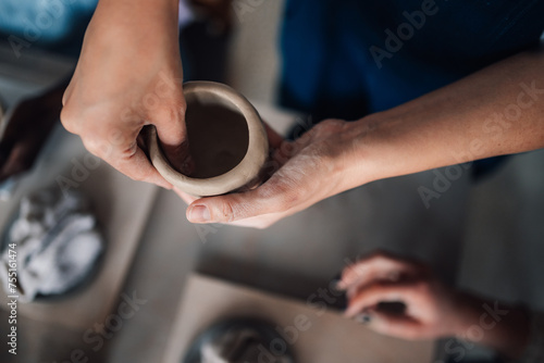 Close up of teacher's hands making pottery on class and teaching attendees