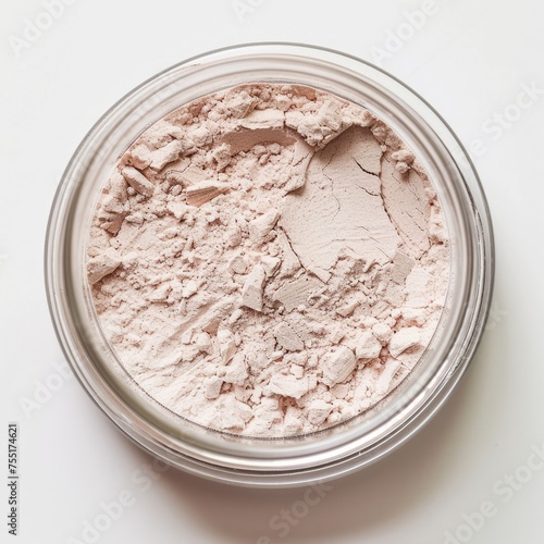 Loose powder contained in a transparent jar, typically used in cosmetics photo