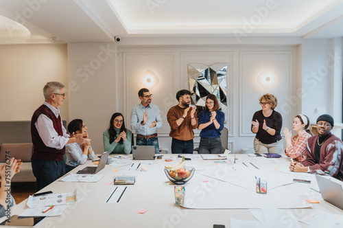 Enthusiastic coworkers clapping and celebrating a successful presentation or achievement in a bright, contemporary office setting, showcasing teamwork and positivity.