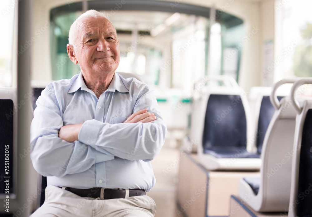 Fototapeta premium Elderly Caucasian man sitting in tram and looking in camera.
