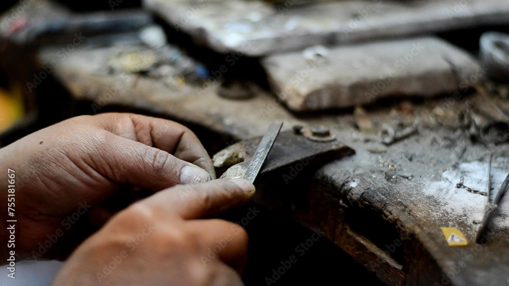 Master jeweler polishing an ornament in a jewelry workshop. Image of hands and product closely. Master jeweler polishing an ornament in a jewelry workshop. Image of hands and product closely.