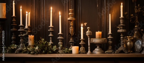 A collection of vintage interior candlesticks with lit candles placed on a wooden table. The warm glow of the flames illuminates the surrounding area.