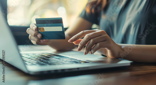 women holding a credit card in her hand while shopping online on a laptop