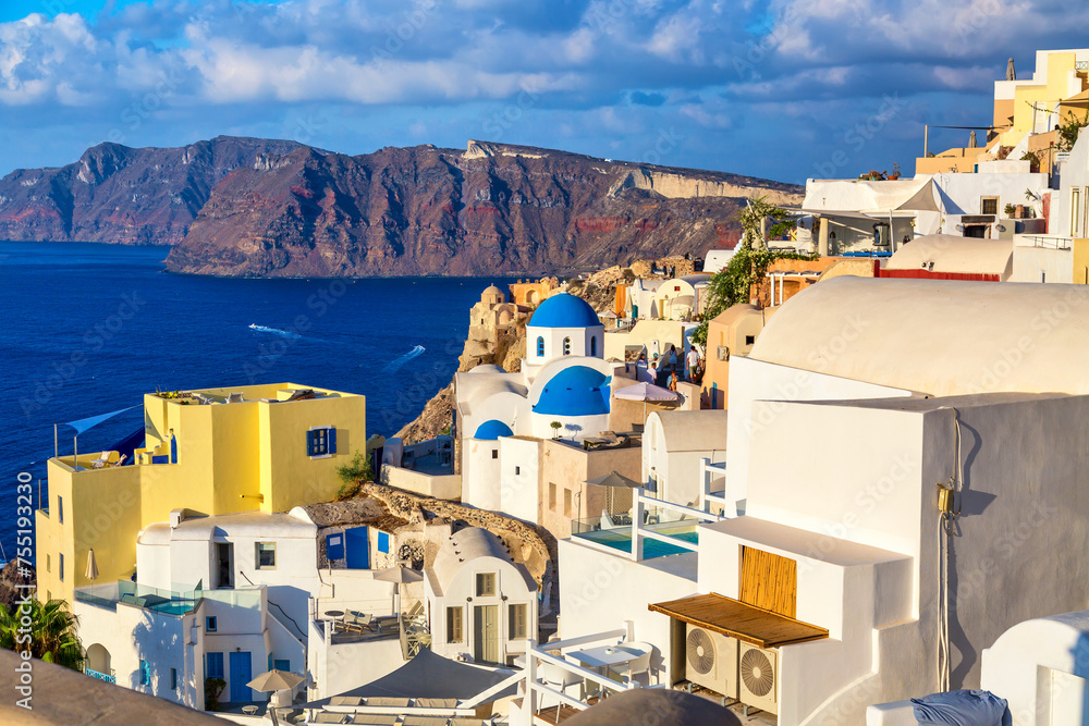 Oia village with famous white houses and blue churches on Santorini island, Aegean sea, Greece.