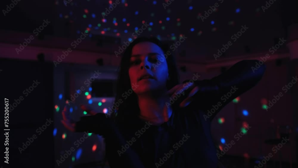 Attractive talented woman dancing modern choreography on blue neon background in studio. Attractive talented woman dancing modern choreography on blue neon background in studio.