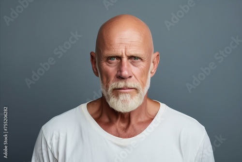 Close up portrait of mature man with grey hair and beard. Isolated on grey background.