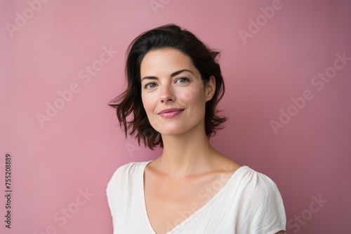 Portrait of a beautiful young woman on a pink background looking at the camera