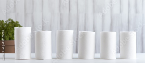 Several white candles are placed on top of a table  creating a simple and elegant display. The candles stand upright  emitting a soft glow against the white backdrop.