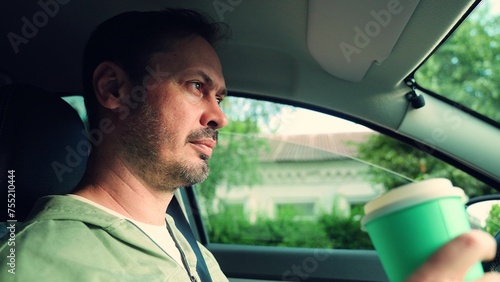 Man quenches thirst on car trip. Man driver drinks fast food drink inside car. Man drink tea, fast food coffee close-up in car. Concept fast food. Delicious food, drinks during family, business trip © zoteva87