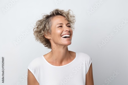 Beautiful middle aged woman with short wavy hair laughing and looking up.