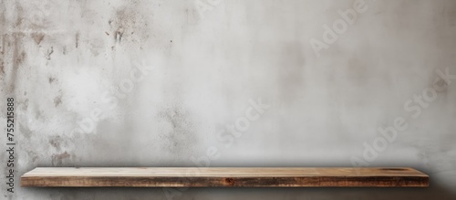 A wooden shelf is positioned in the corner of a room, against a concrete cement wall. The shelf is empty and is suitable for displaying or arranging various items.