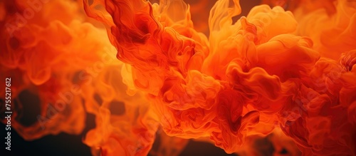 This close-up shot captures a vibrant mix of red and orange substances, resembling a blend of ink and fire flames. The dynamic textures and colors create an abstract art background that was shot on a