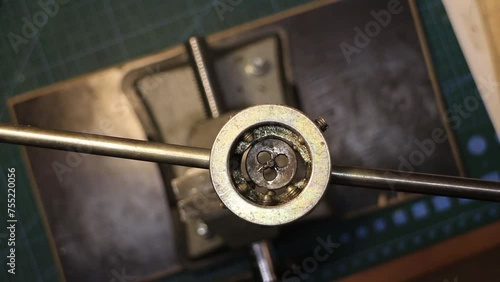 mechanic cuts a thread by hand using a die, top view photo