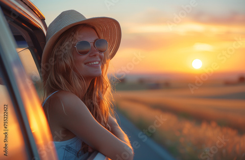 happy smiling girl in sunglass at the holidays in hat at the car lokking at the sun on blue sky