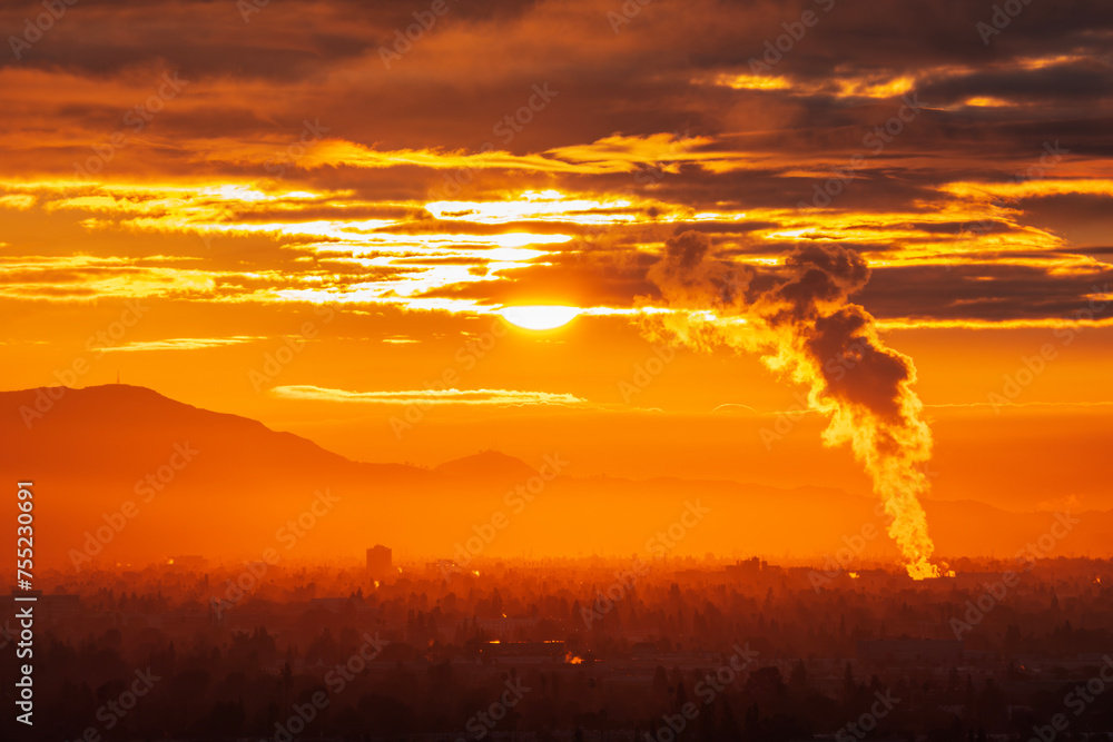 Industrial steam billowing into glowing sunrise above the San Fernando Valley in Los Angeles California.  