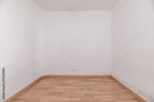 An empty room with white painted walls and wooden floors