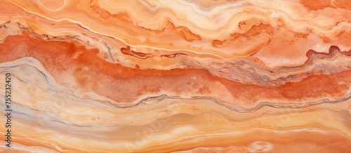 This close-up view showcases the intricate patterns of an orange and white marble surface. The vibrant colors and smooth texture are visible, highlighting the natural beauty of the material.