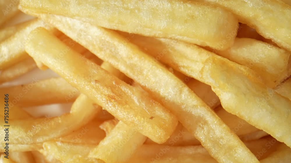Crispy, golden French fries, beloved worldwide, are thinly sliced potatoes deep-fried to perfection, offering a delightful crunch and irresistible flavor. Food concept. French fries background. 4K.
