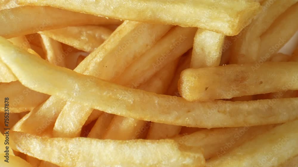 French fries, also known as fries or chips, are thinly cut strips of potatoes that are deep-fried until crispy and golden brown. Food concept. Shot with 24mm probe macro lens. French fries background. French fries, also known as fries or chips, are thinly cut strips of potatoes that are deep-fried until crispy and golden brown. Food concept. Shot with 24mm probe macro lens. French fries background.