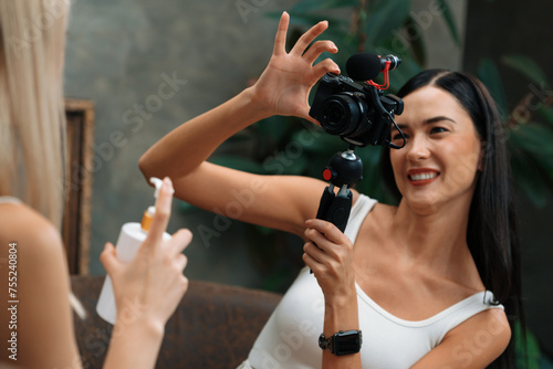 Two beautiful content creator making natural beauty and cosmetic tutorial on green plant leave garden video. Beauty blogger showing how to beauty care to social medial audience by selfie stick. Blithe