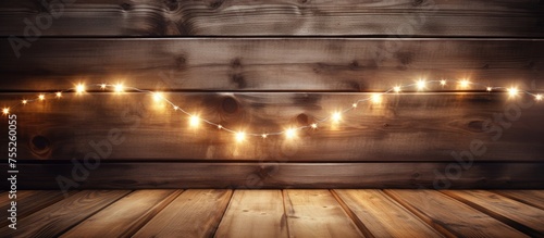 The hardwood flooring complements the wooden wall, creating a warm and inviting space. Christmas lights in the background add a festive touch