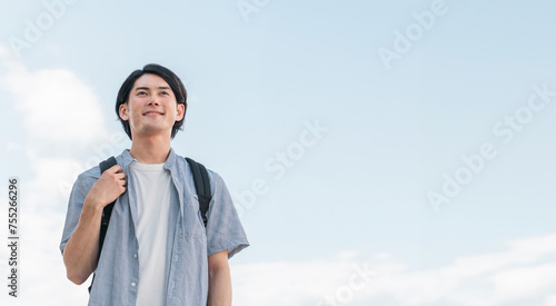 青空の下にいる笑顔の学生・大学生の男性（進学・受験・チャレンジ・希望・目標）
 photo