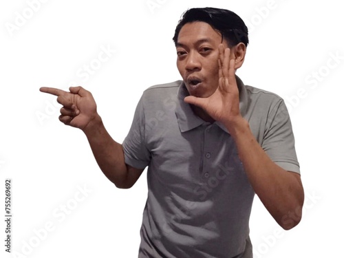 Shocked Asian man wearing gray t-shirt is pointing at the copy space beside him, isolated by white background