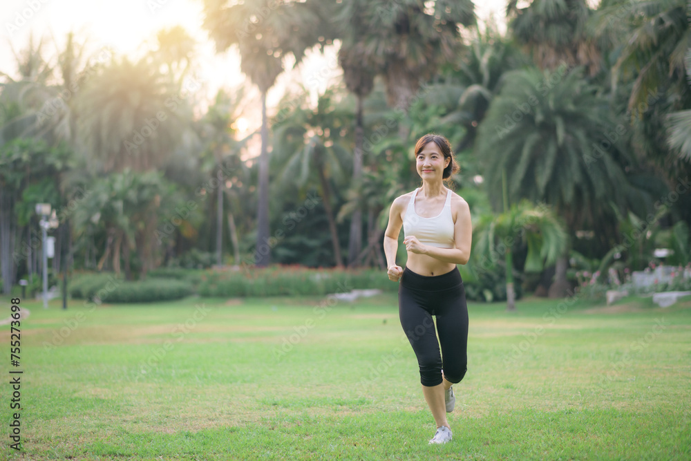pretty asian woman jogger running in green nature public park. pretty asian woman jogger running in green nature public park.