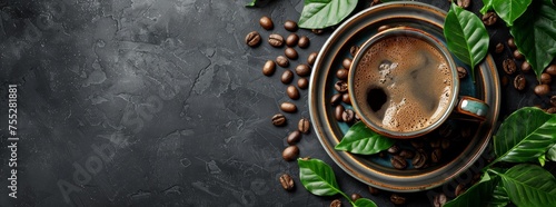 Espresso in a ceramic cup with coffee beans and green leaves on a dark stone background. photo