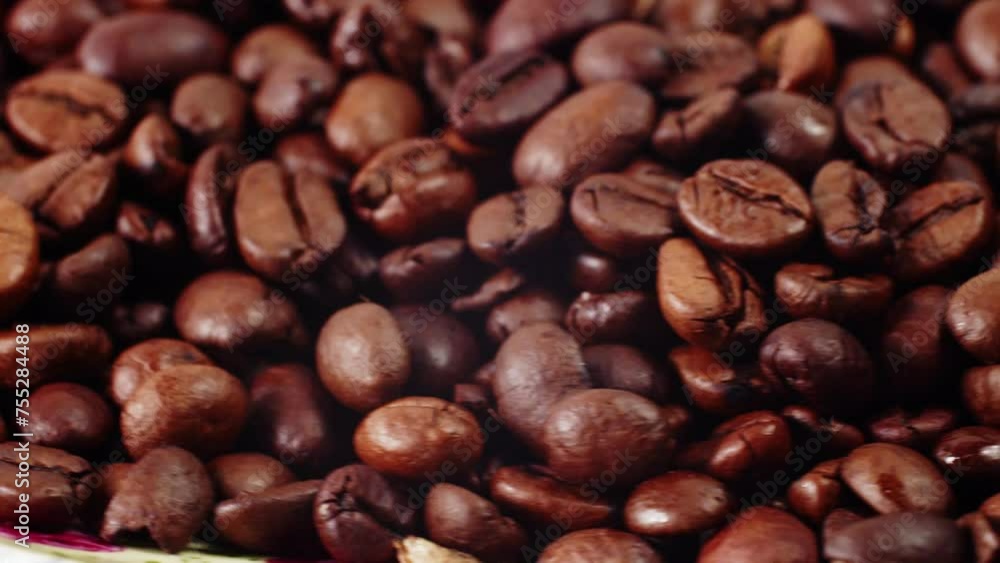 Roasted coffee beans rotate, coffee beans background. Coffee beans background. Textured background of freshly roasted coffee beans Roasted coffee beans rotate, coffee beans background. Coffee beans background. Textured background of freshly roasted coffee beans