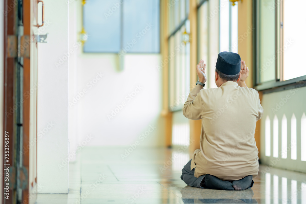 Ramadan, Muslim, Isalam, An Asian Muslim man is praying with peace in the beautiful mosque, giving a powerful atmosphere of faith, with copy space, Islam concept.