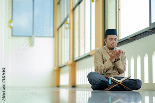 Ramadan, Quran, Islam, An Asian Muslim man is sitting and reading the Quran. The peace in the mosque makes it an energetic atmosphere of faith, with copy space.