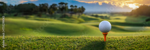 golf course in the evening at sunset with golf ball on tee, panoramic banner, copy space