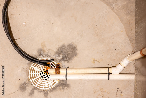 Foto Selective focus on a residential house basement floor drain with furnace and wat