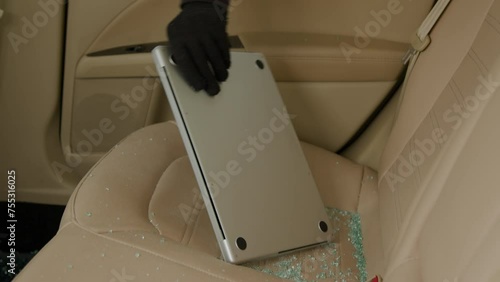 Laptop from the back seat is stolen through a broken window, the aftermath of a car break-in. photo