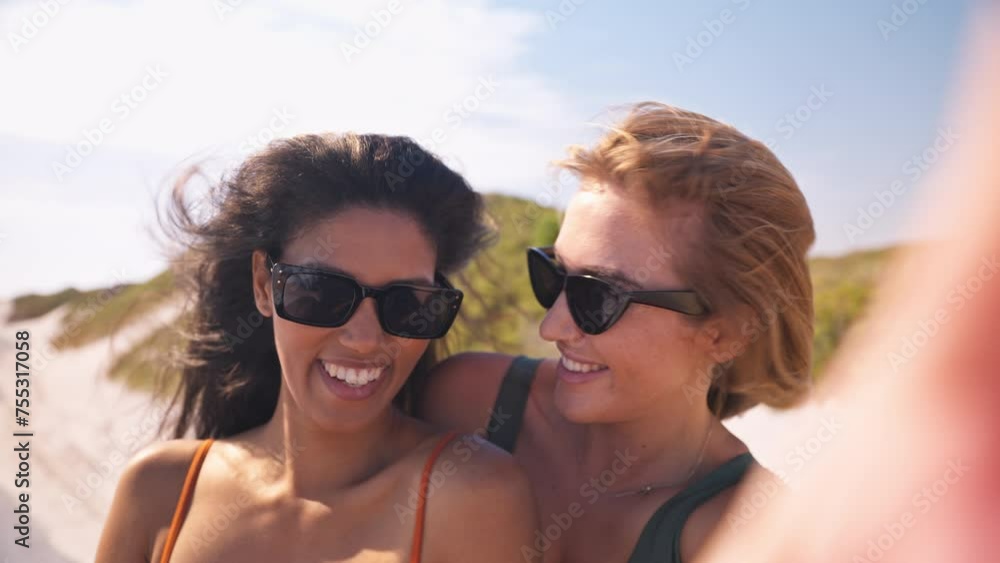 Two young women with friends on vacation posing for selfie standing up in moving car on road trip adventure to beach - shot in slow motion Two young women with friends on vacation posing for selfie standing up in moving car on road trip adventure to beach - shot in slow motion