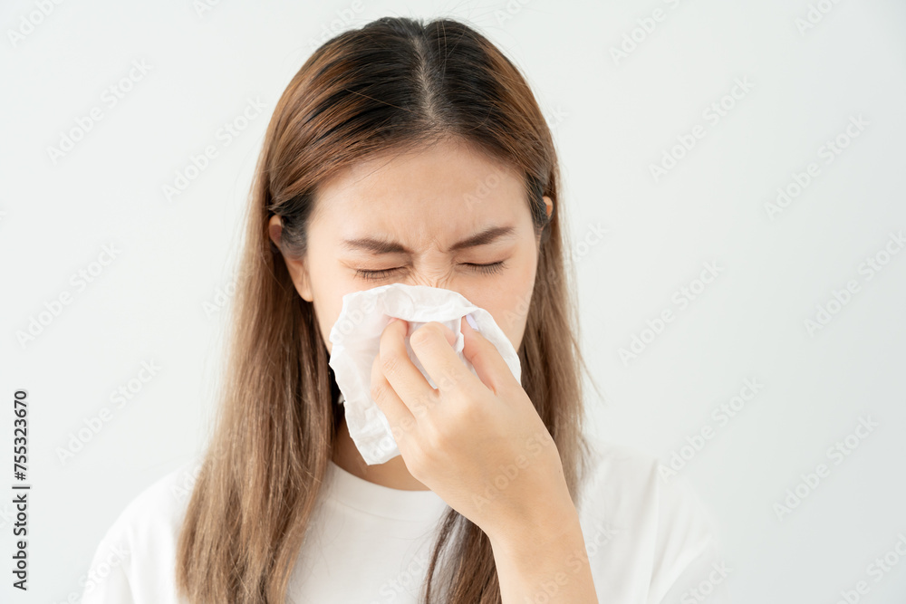 Pollen Allergies, asian young woman sneezing in a handkerchief or blowing in a wipe, allergic to wild spring flowers or blossoms during spring. allergic reaction, respiratory system problems Pollen Allergies, asian young woman sneezing in a handkerchief or blowing in a wipe, allergic to wild spring flowers or blossoms during spring. allergic reaction, respiratory system problems