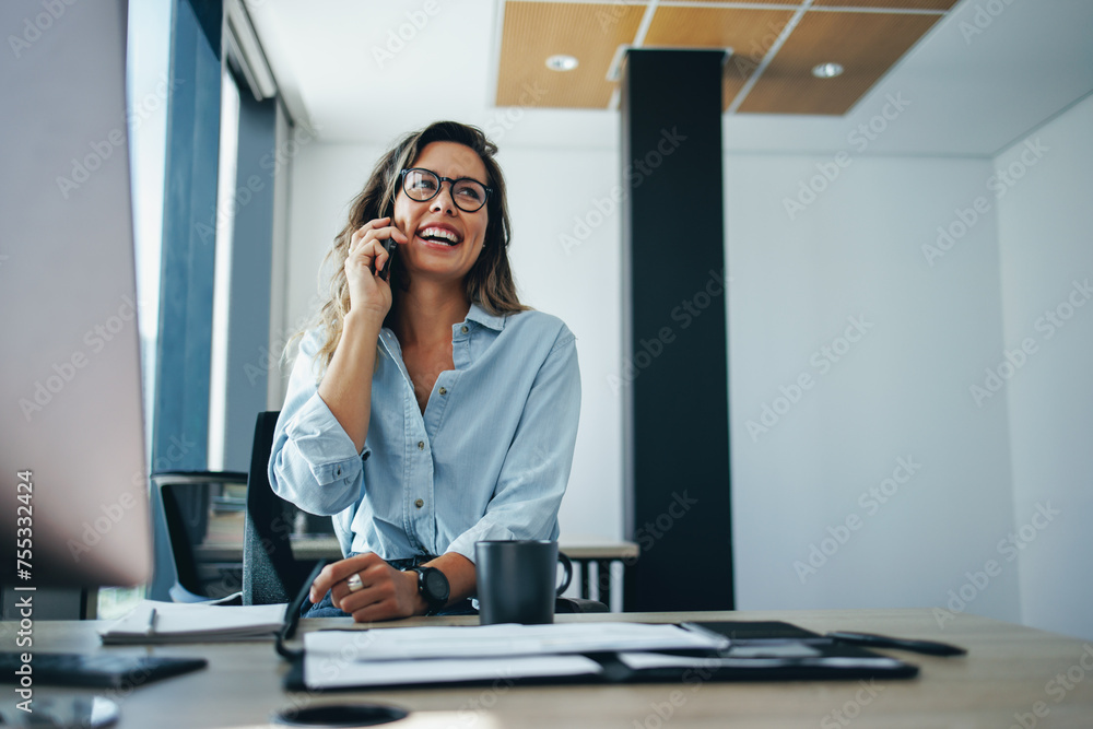 Business woman speaking on the phone at her office desk Business woman speaking on the phone at her office desk