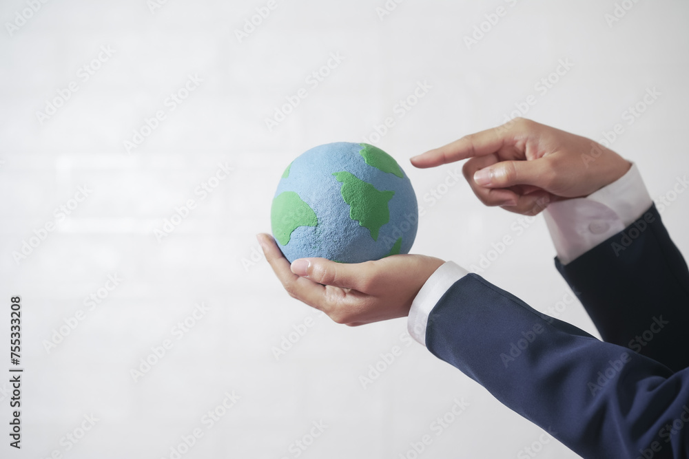 Woman's hand holding the globe, wearing a suit, white background Woman's hand holding the globe, wearing a suit, white background