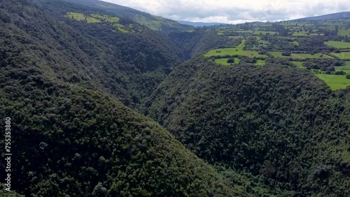 Kinematic drone movement over a plant-covered canyon and river at Puichig, Pasochoa volcano, Machachi, Ecuador photo