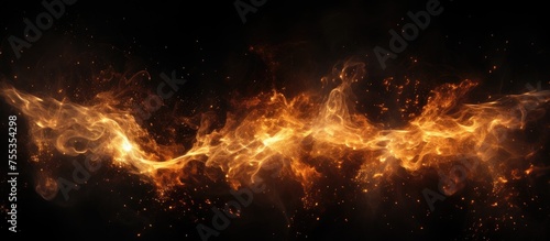 A fiery blaze of orange and yellow flames crackling and emitting sparks against a stark black backdrop, creating a striking contrast in colors.
